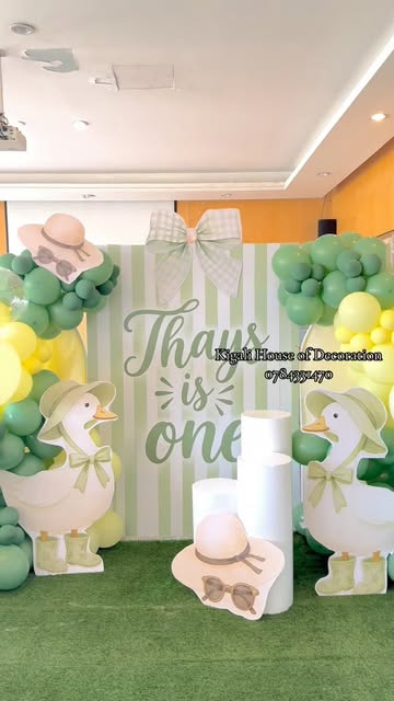 Duck-themed first birthday with sage stripes and a big bow